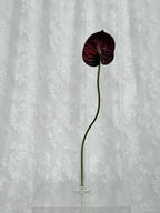 Artificial large anthurium flower by Fleuristic with vibrant red petals and lush green leaves, perfect for decorative arrangements.