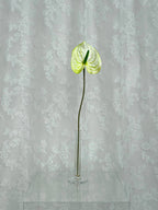 Artificial large anthurium flower by Fleuristic, showcasing vibrant red petals and lush green leaves for decorative use.