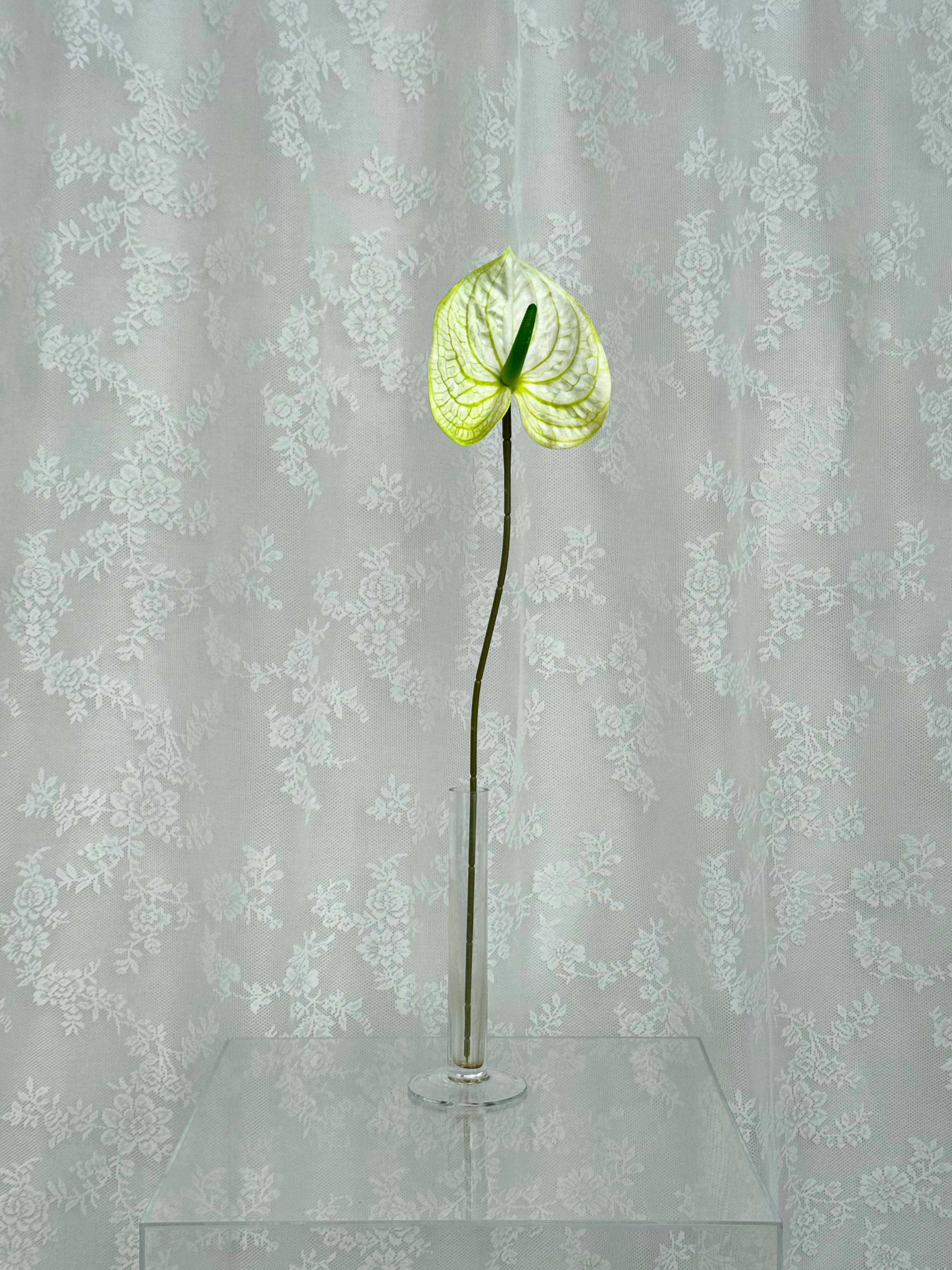 Artificial large anthurium flower by Fleuristic, showcasing vibrant red petals and lush green leaves for decorative use.