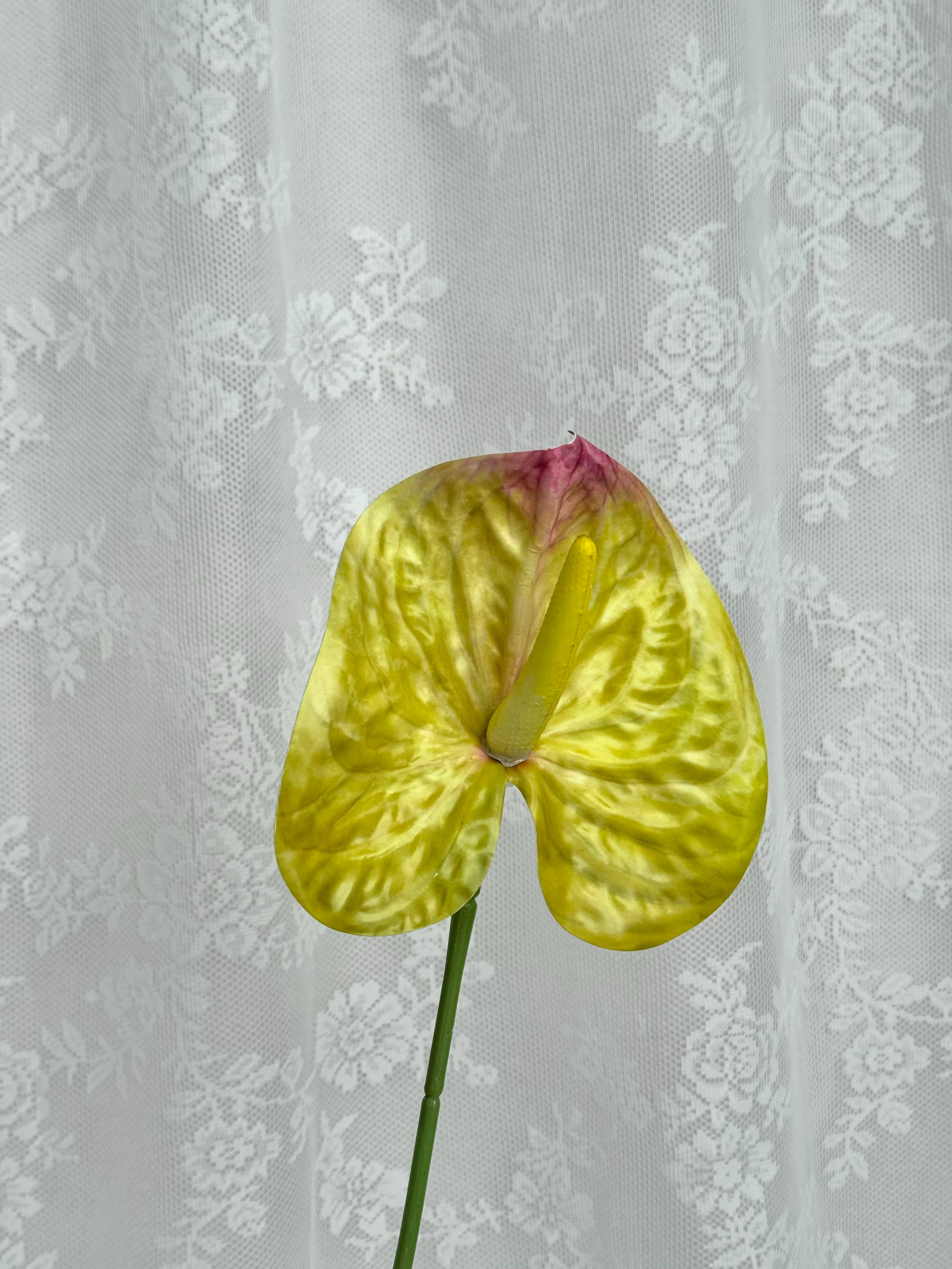 Artificial large anthurium flower by Fleuristic with vibrant red petals and lush green leaves, perfect for home decor.