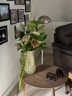 Fleuristic Green Forest artificial flower bouquet with lush green foliage and detailed leaves in a cozy indoor setting