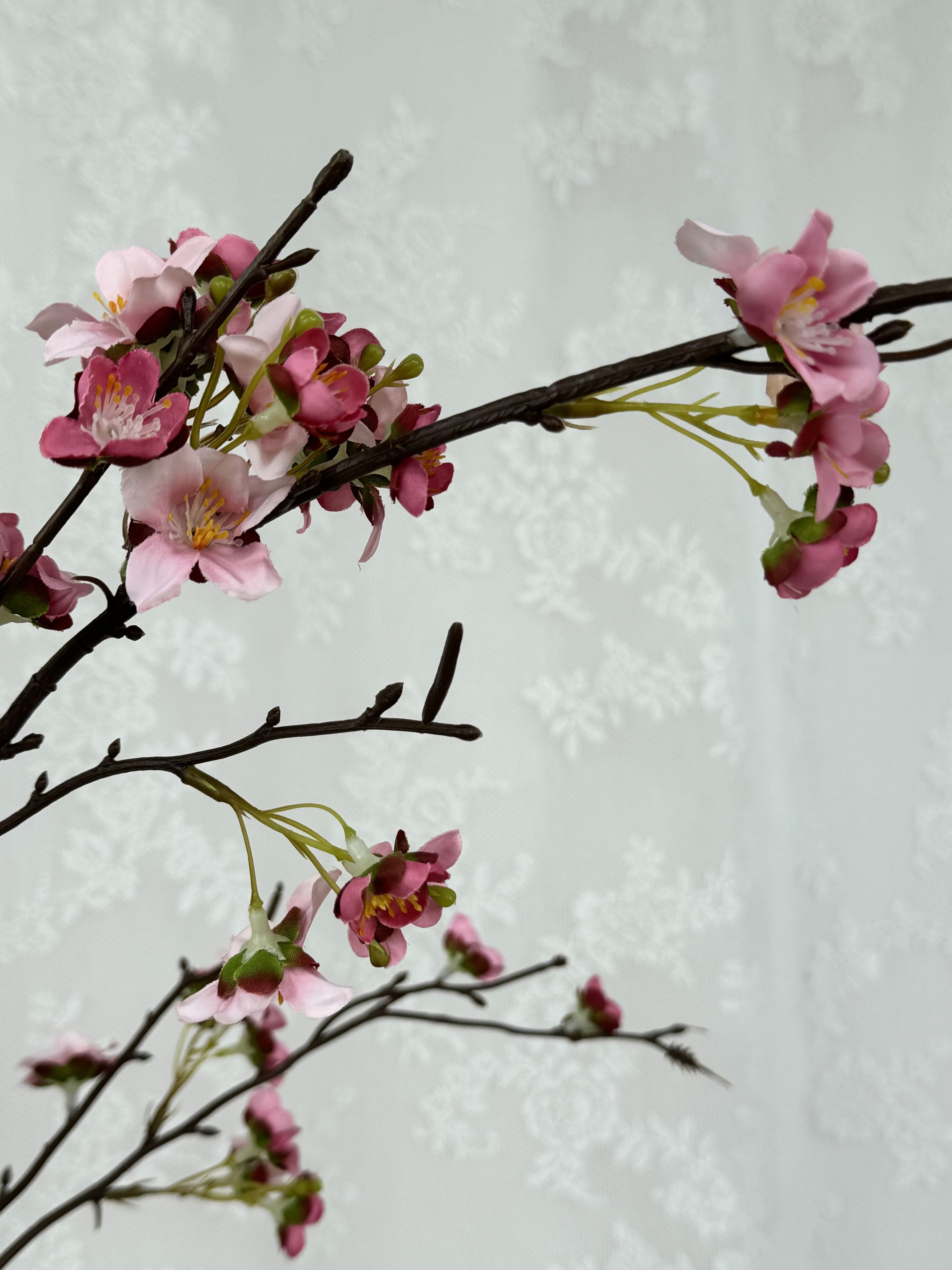 Artificial pink cherry blossom branch by Fleuristic, detailed view of vibrant blooms and delicate pink flowers.
