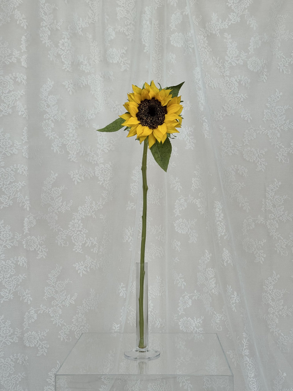 Realistic artificial sunflower by Fleuristic with vibrant yellow petals and green leaves for home decor.