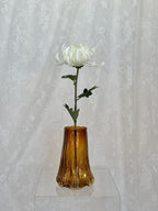 Large white artificial chrysanthemum flower from Fleuristic, showcasing realistic petals and lush green leaves.