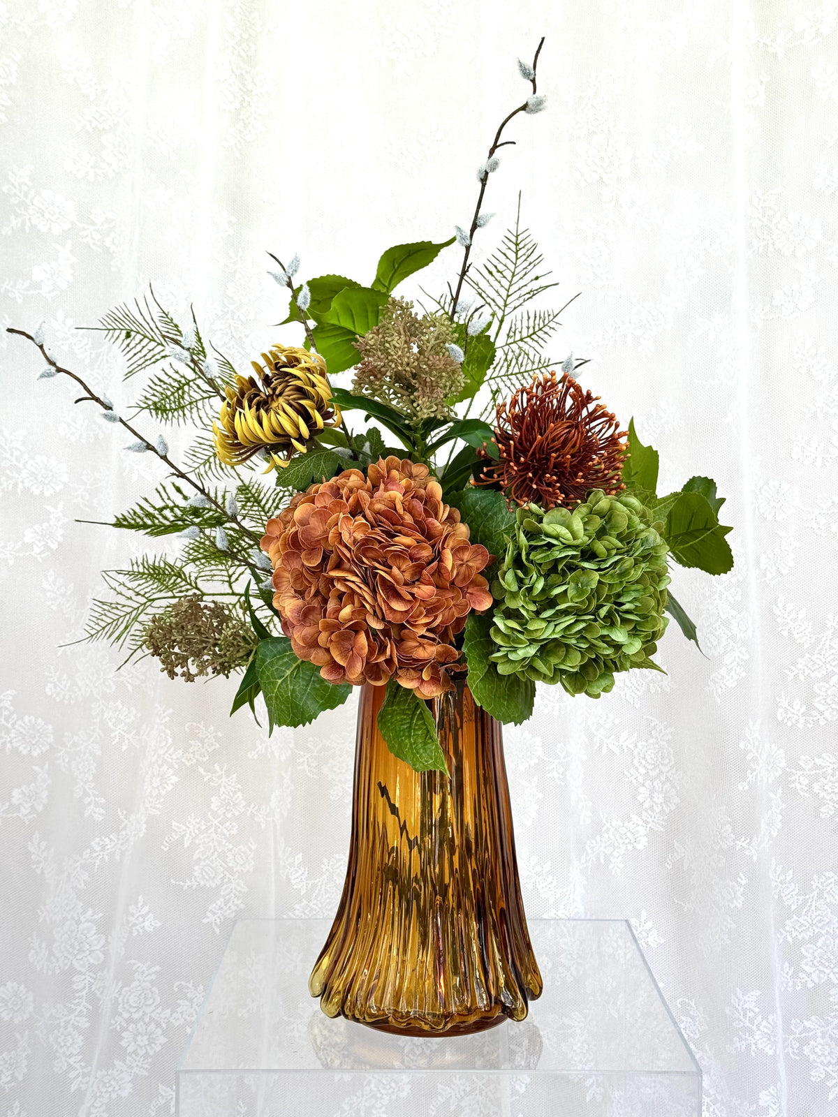 Artificial floral bouquet called Amber Bloom by Fleuristic featuring vibrant, realistic amber-colored flowers and greenery.
