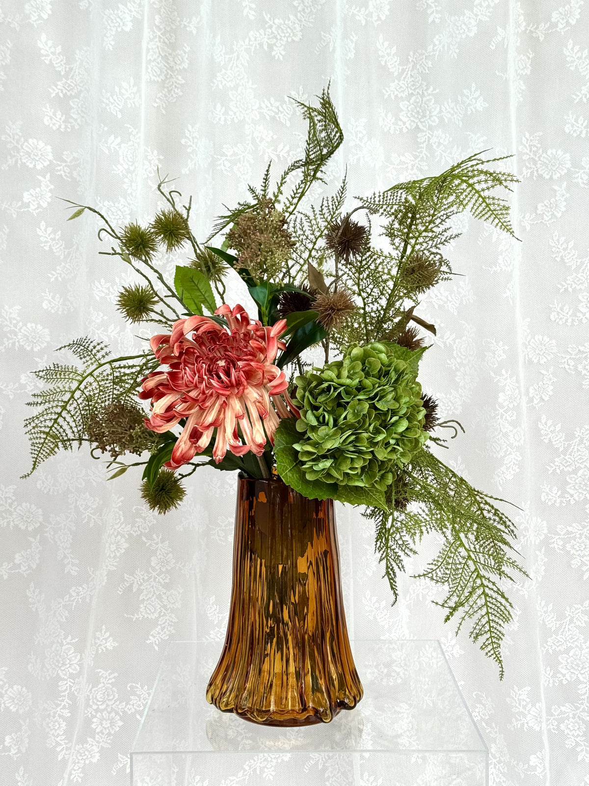 Artificial floral arrangement of amber-colored flowers in a bouquet, featuring natural-looking petals and greenery, from Fleuristic.