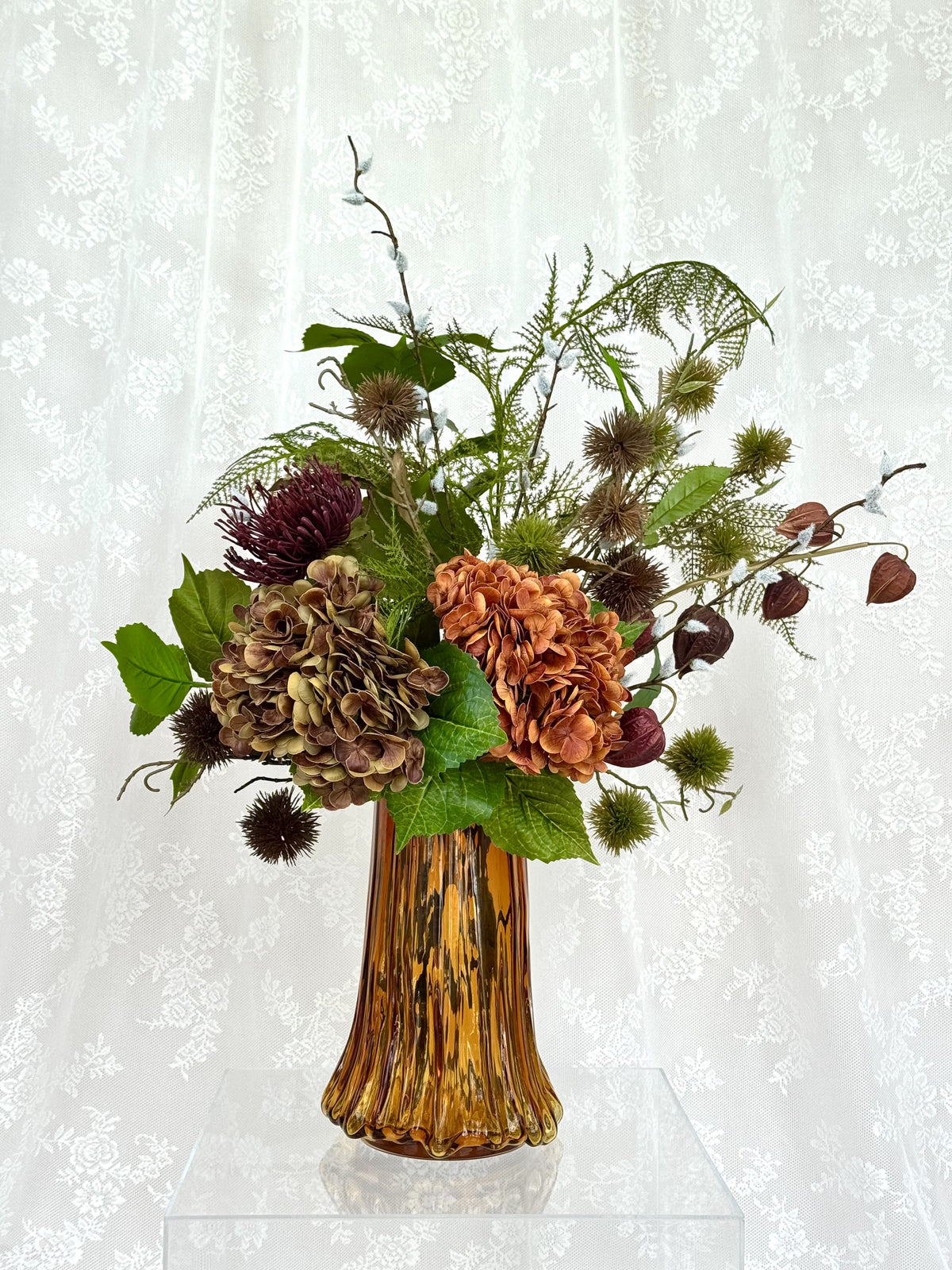 Artificial floral arrangement named Burnt Harmony by Fleuristic featuring a mix of burnt orange and earthy-toned flowers.