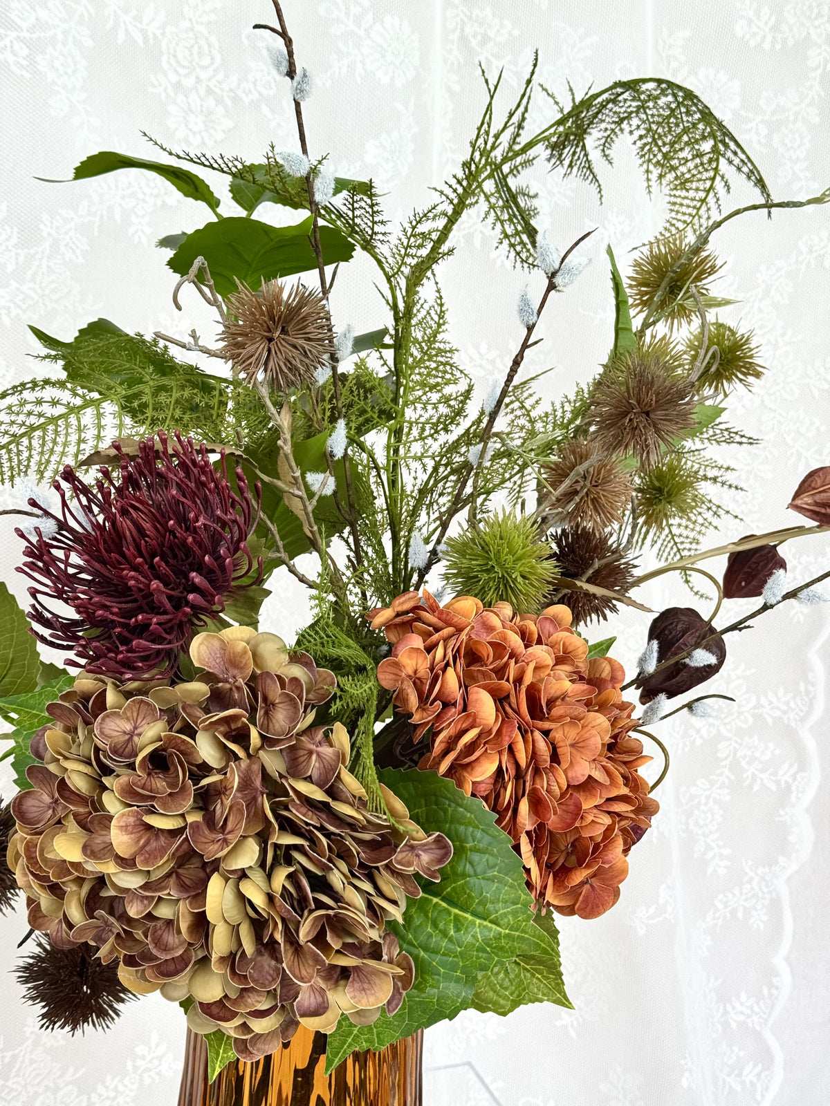 Fleuristic Burnt Harmony artificial flower bouquet with warm-toned, realistic faux flowers in a dense arrangement.