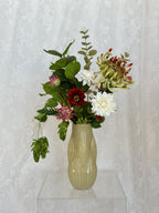 Artificial flower bouquet in red and green hues, designed by Fleuristic, resembling a lush forest scene.
