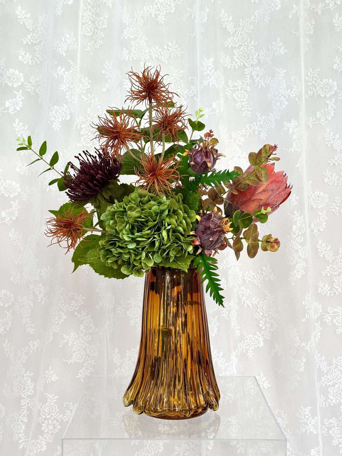 Artificial floral arrangement named Rich Autumn by Fleuristic featuring warm autumn-colored leaves and blooms in a decorative display.