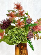 Artificial floral arrangement with rich autumn-colored flowers in a Fleuristic bouquet for fall decoration.