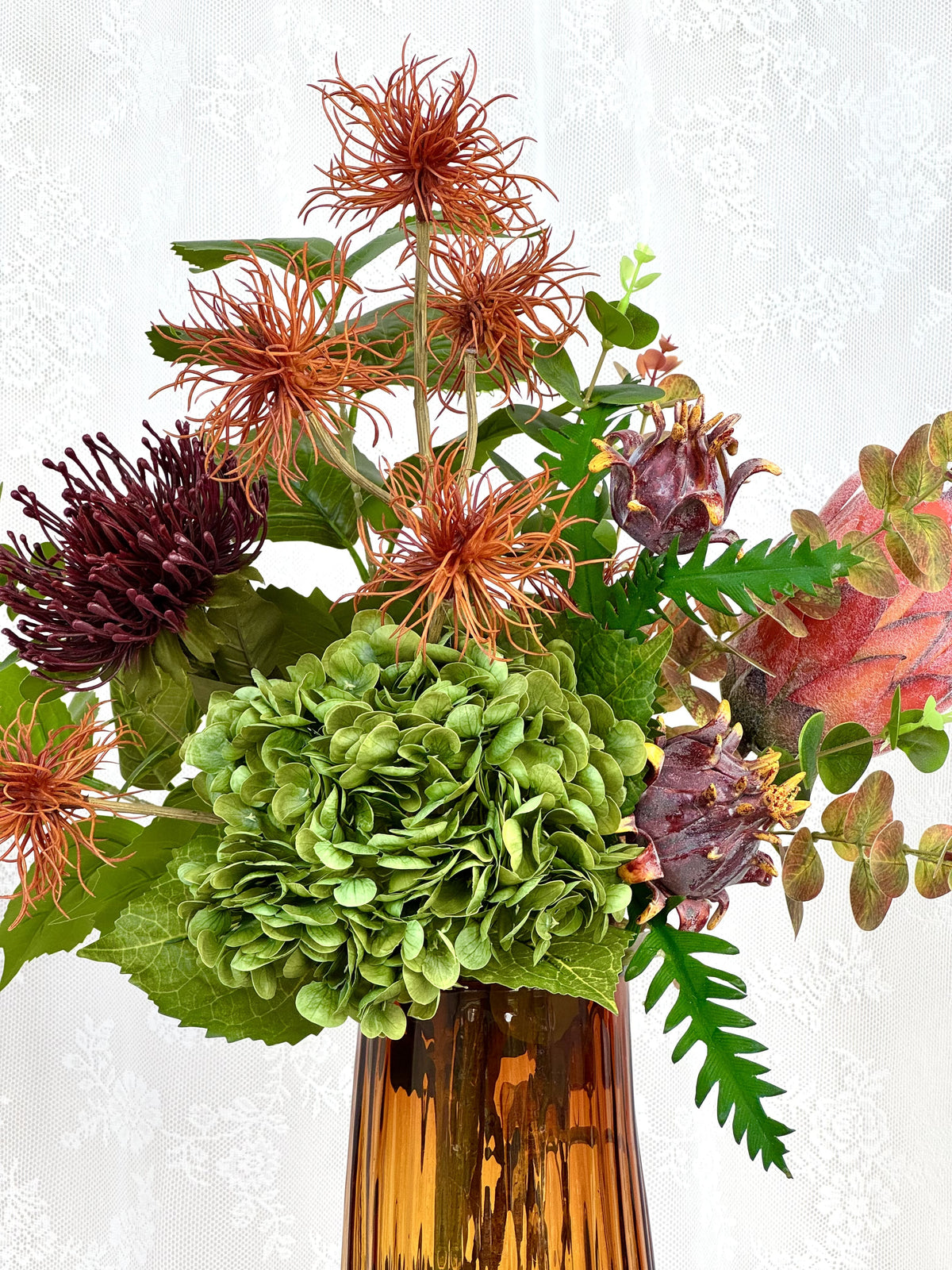 Artificial floral arrangement with rich autumn-colored flowers in a Fleuristic bouquet for fall decoration.