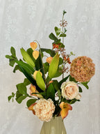 Artificial floral bouquet named Sunset Dream by Fleuristic, featuring vibrant sunset-colored flowers and lush greenery.