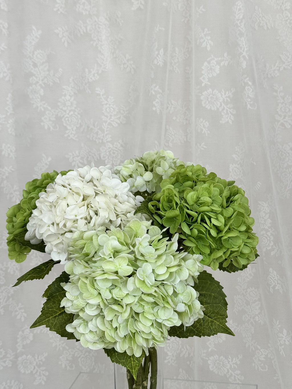 Artificial green hydrangea flower bouquet from Fleuristic, showing detailed lush green hydrangea blossoms.