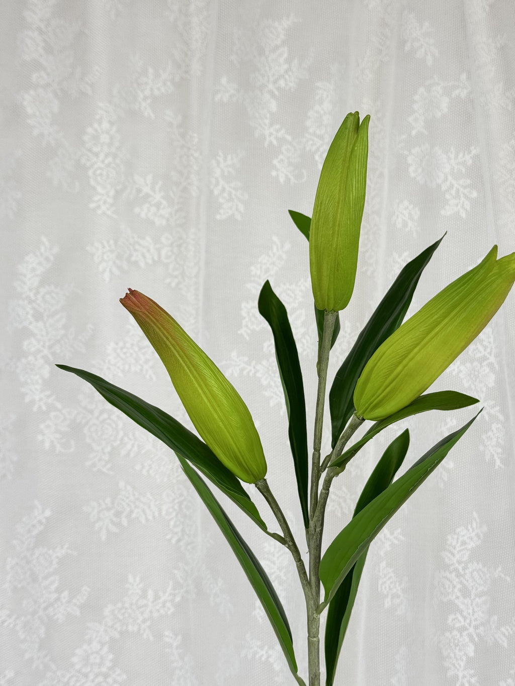 Close-up of realistic artificial lily flowers by Fleuristic, showcasing detailed petals and vibrant coloration.