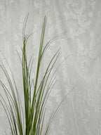 Fleuristic artificial green grass (siv) with detailed lush blades, ideal for home decor or landscaping accents.