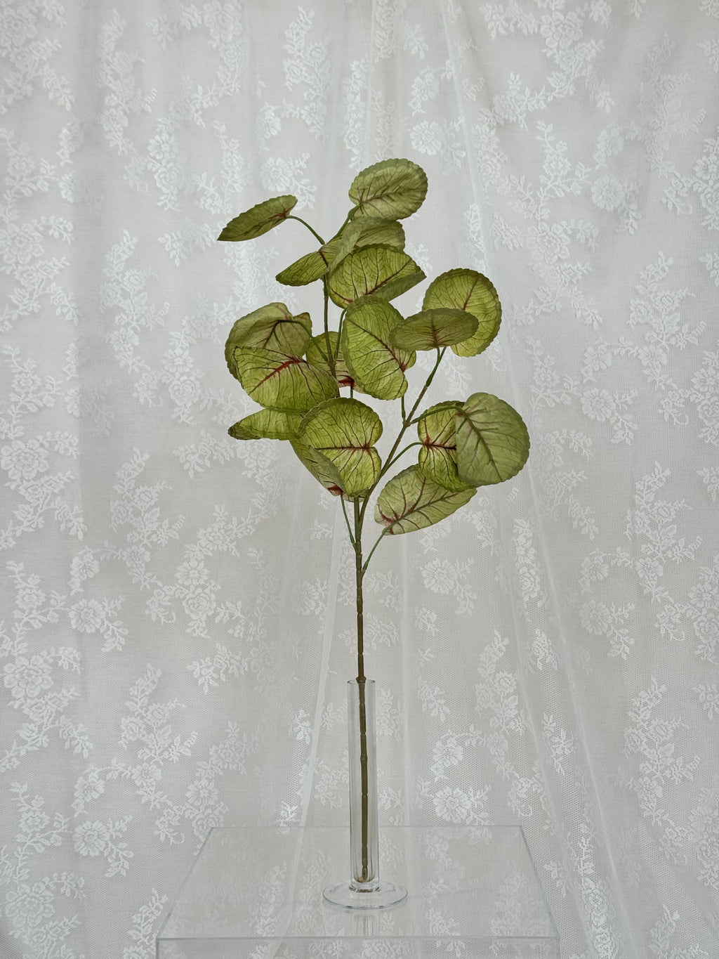 Fleuristic artificial green and red blades with realistic leaf detailing on a natural background.
