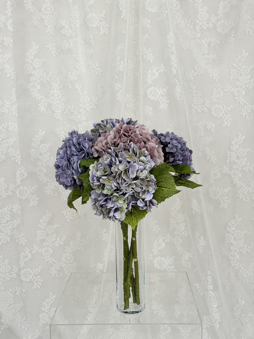 Lilla kunstig hortensibuket in a floral arrangement from Fleuristic, showcasing detailed, lifelike artificial flowers.