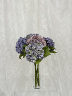 Lilla kunstig hortensibuket in a floral arrangement from Fleuristic, showcasing detailed, lifelike artificial flowers.