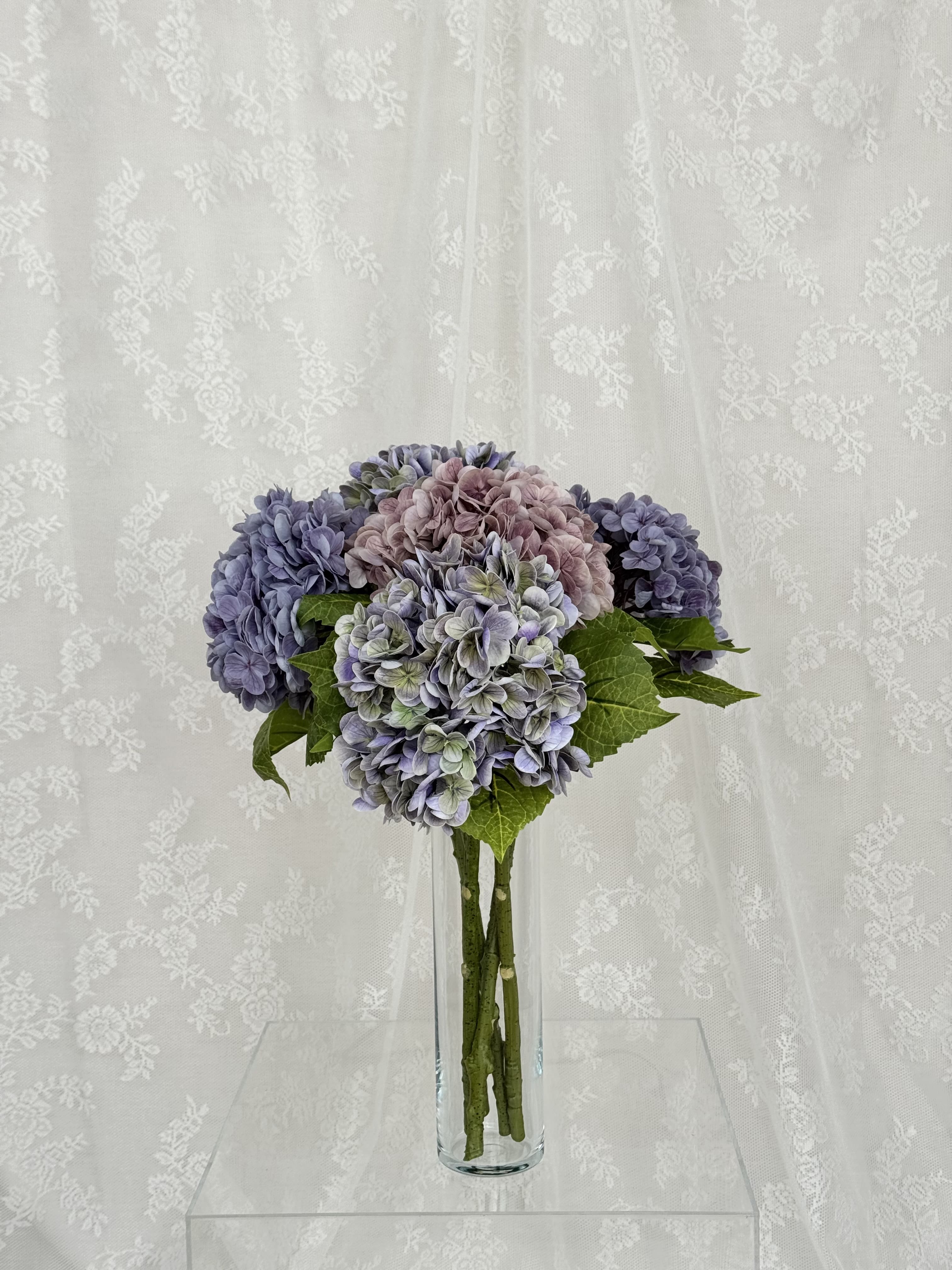 Lilla kunstig hortensibuket in a floral arrangement from Fleuristic, showcasing detailed, lifelike artificial flowers.