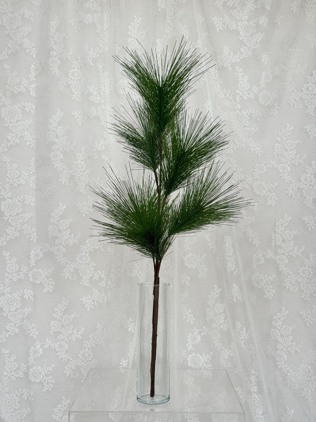 Fleuristic artificial fir branch with green pine needles, realistic artificial greenery for holiday decorating.
