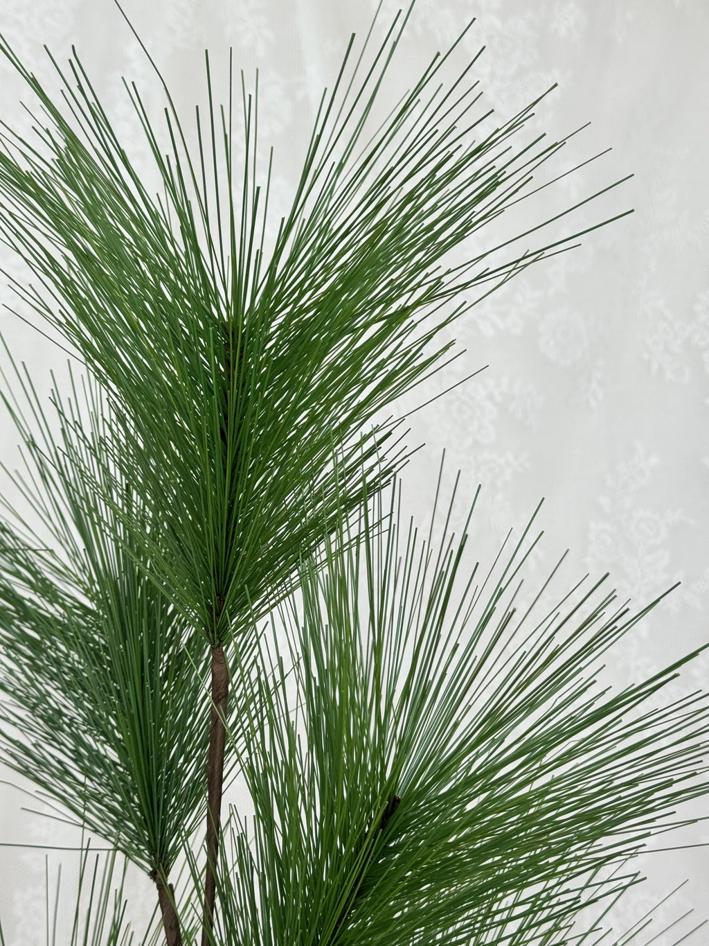 Fleuristic artificial fir branch with realistic green needles for holiday decorating or craft projects.
