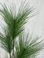 Fleuristic artificial fir branch with realistic green needles for holiday decorating or craft projects.