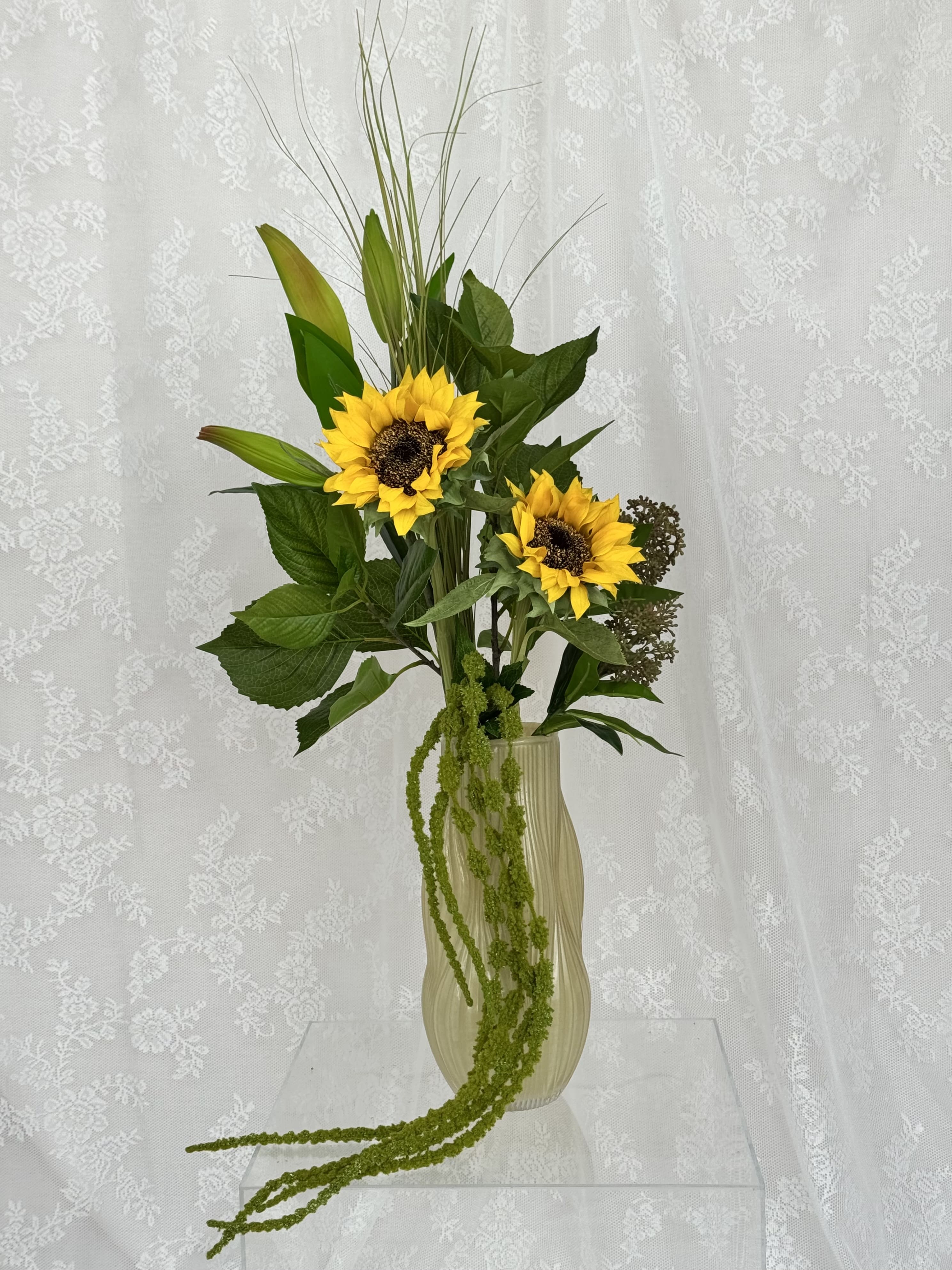 Artificial sunflower greens bouquet from Fleuristic with vibrant green leaves and sunflower accents in a natural arrangement.