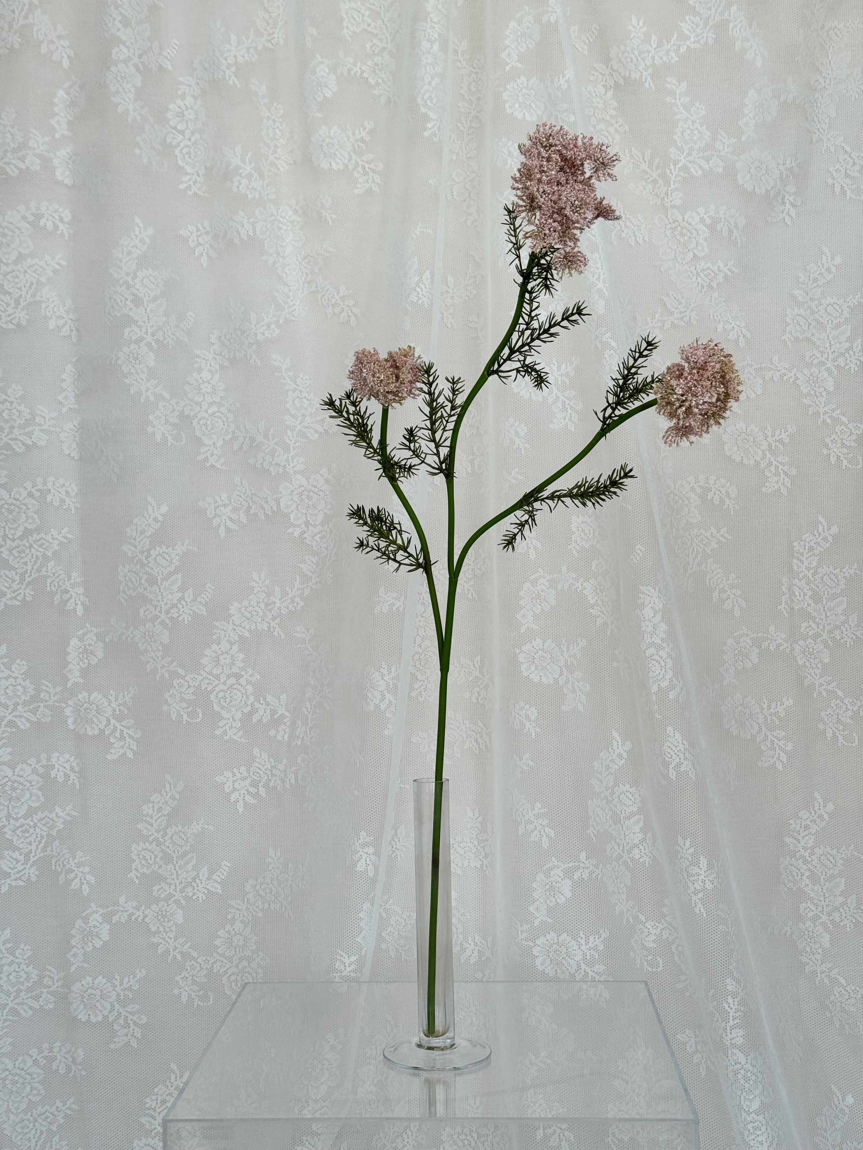 Artificial wild carrot flower by Fleuristic, showcasing vibrant orange, textured petals, and lush green foliage in a realistic design.